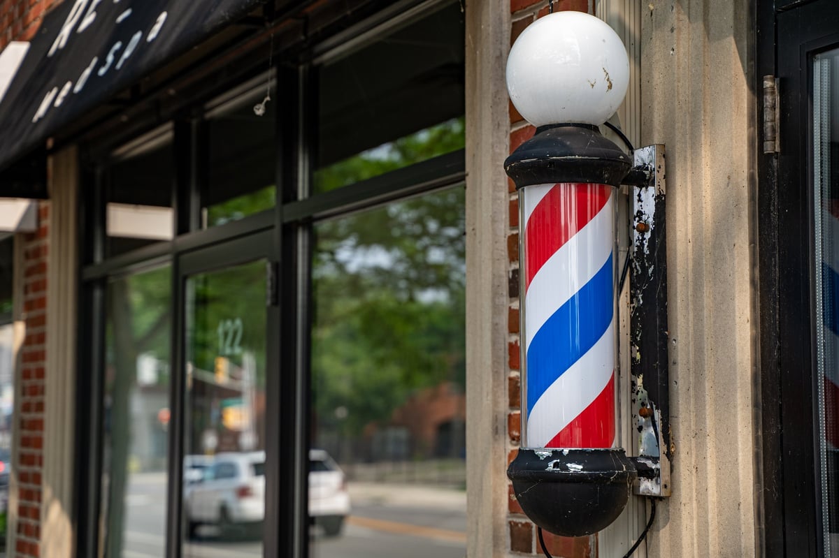 View of barber pole in front of barbershop